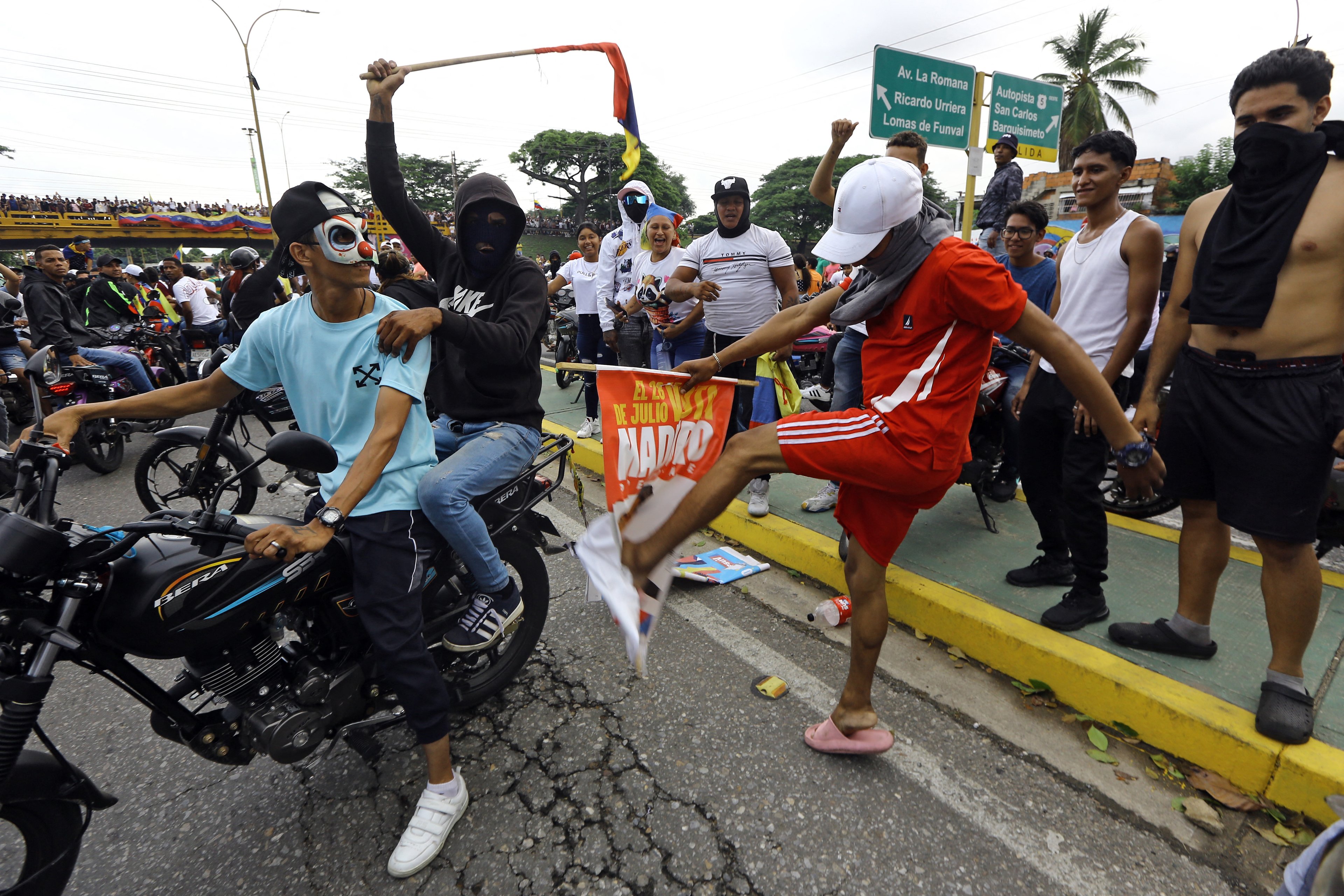 Um manifestante chuta uma faixa de campanha do presidente venezuelano Nicolás Maduro durante um protesto em Valência, no estado de Carabobo.