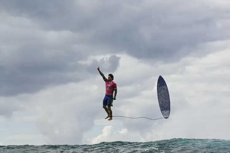 Foto de Gabriel Medina após pegar uma grande onda na 5ª bateria da 3ª rodada do surf masculino, durante os Jogos Olímpicos de Paris 2024 (Jerome BROUILLET/AFP)