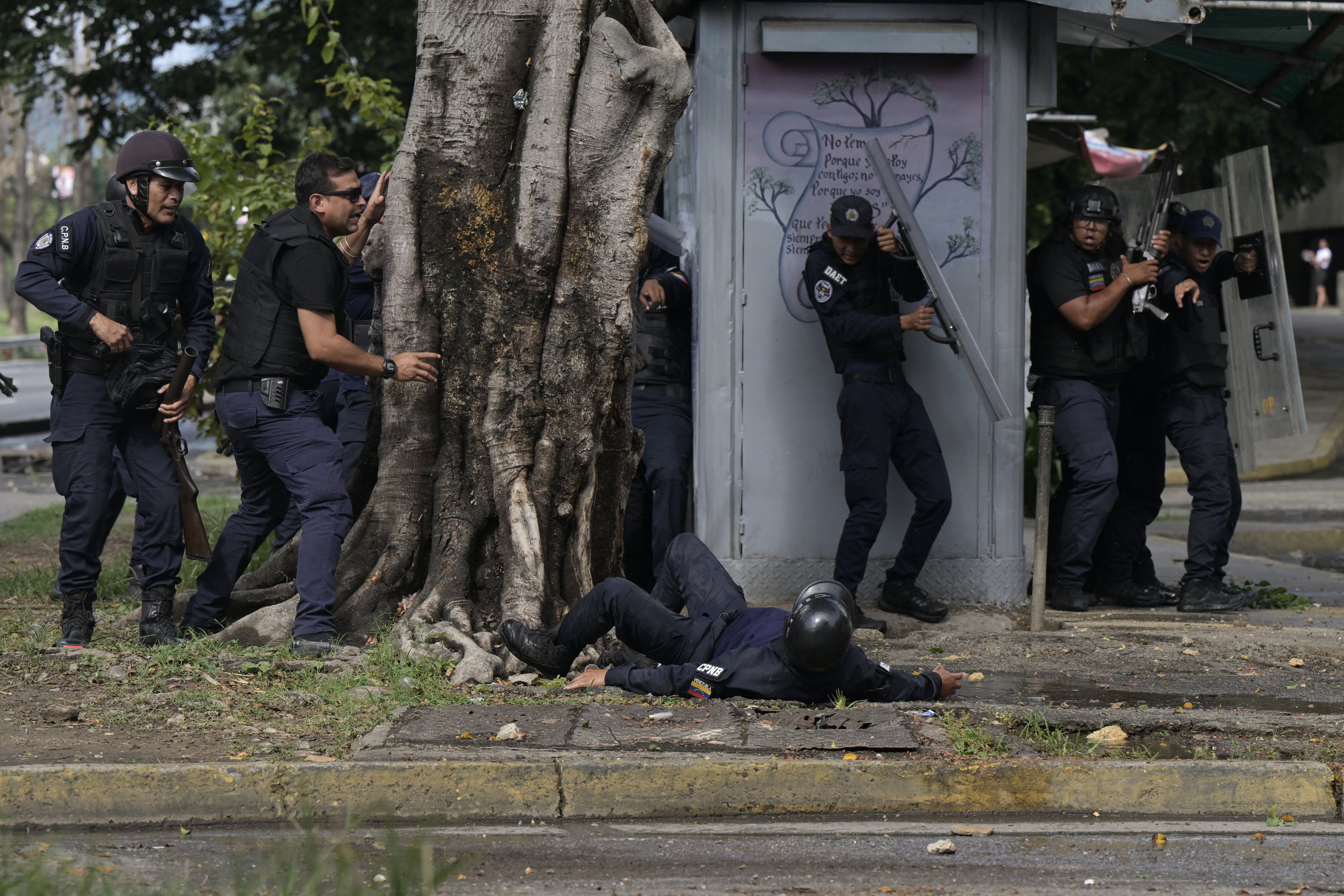Um policial cai no chão ferido durante um protesto contra o governo do presidente Nicolás Maduro em Caracas..