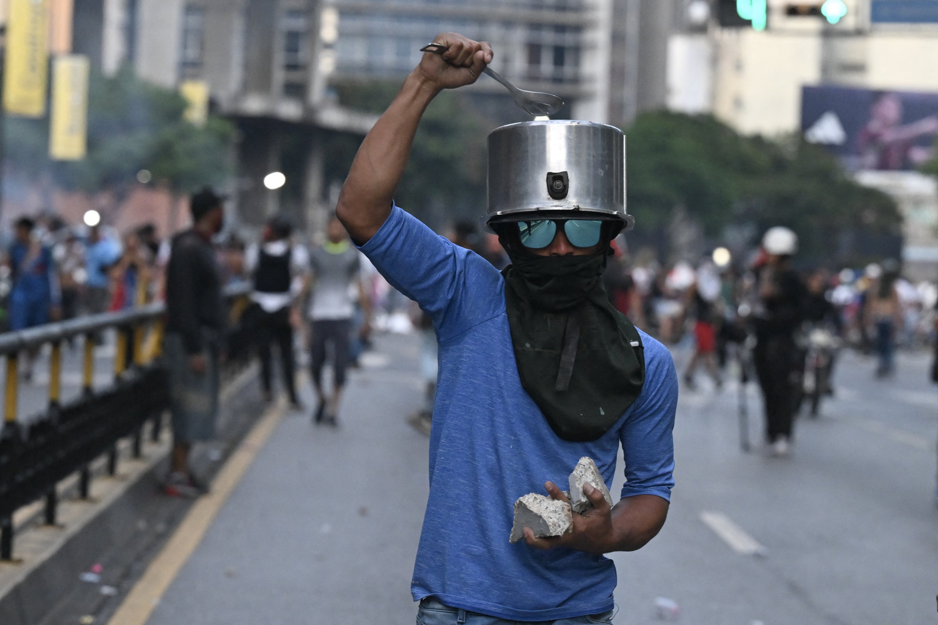 Um manifestante bate uma panela na cabeça durante um protesto contra o presidente venezuelano Nicolás Maduro em Caracas.
