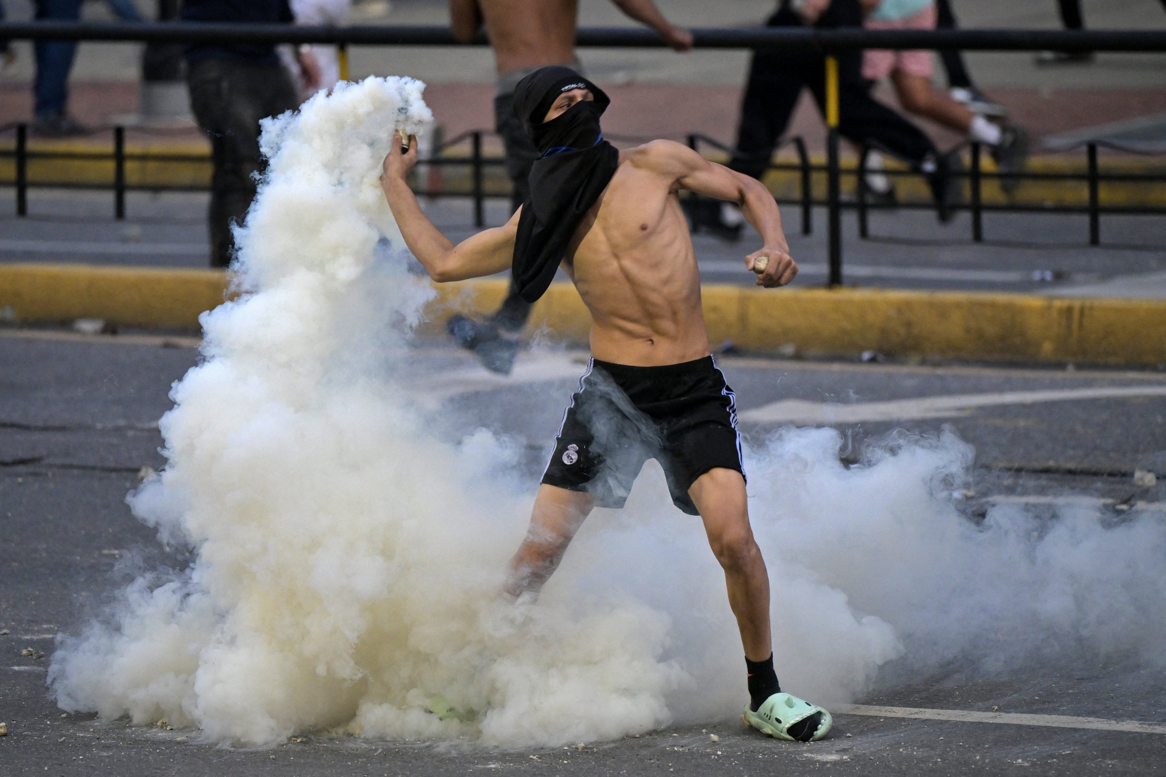 Um manifestante devolve à polícia uma lata de gás lacrimogêneo durante um protesto contra o governo do presidente venezuelano Nicolás Maduro em Caracas.