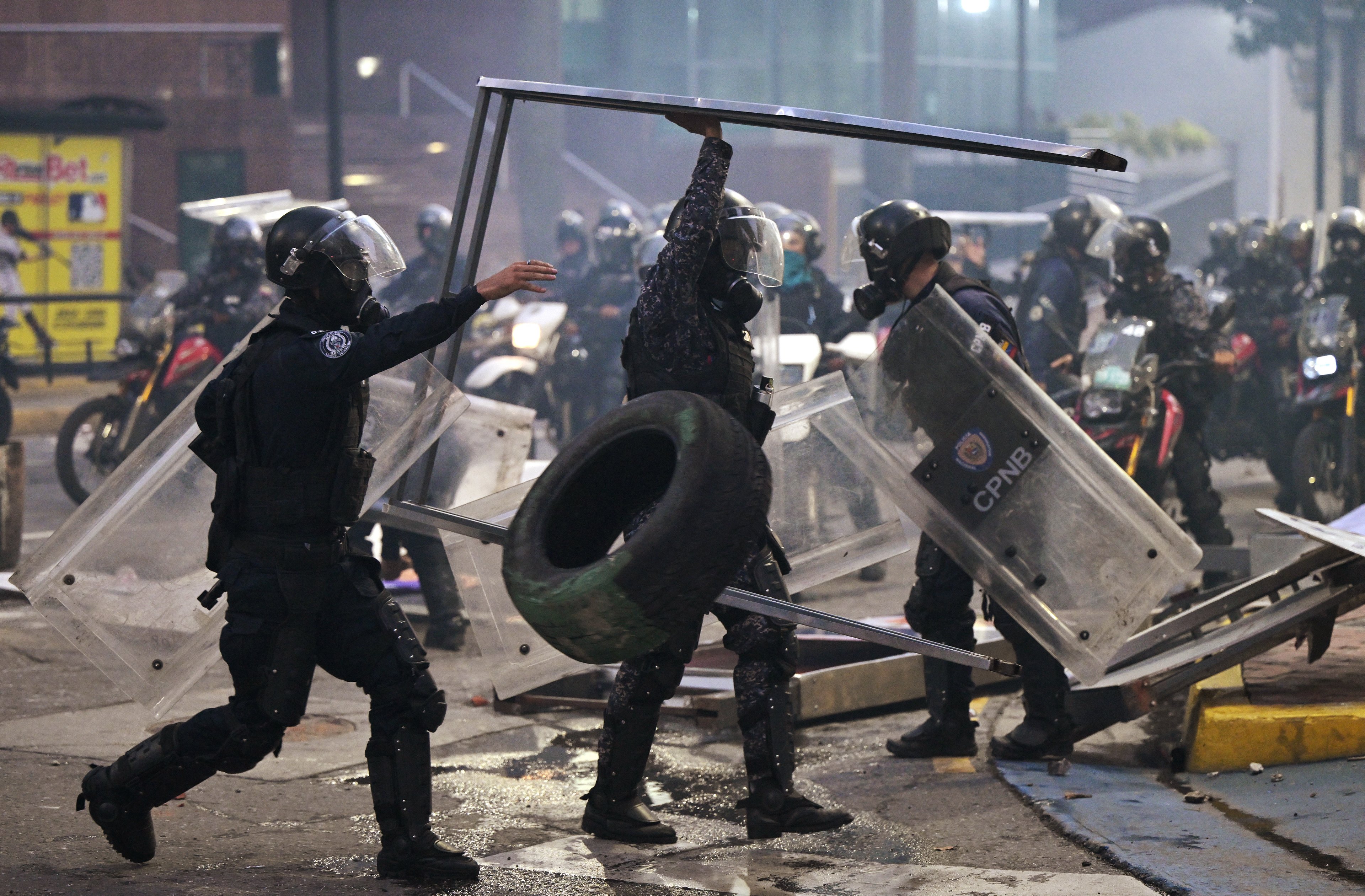 Policiais removem destroços durante um protesto contra o governo do presidente venezuelano Nicolás Maduro em Caracas.