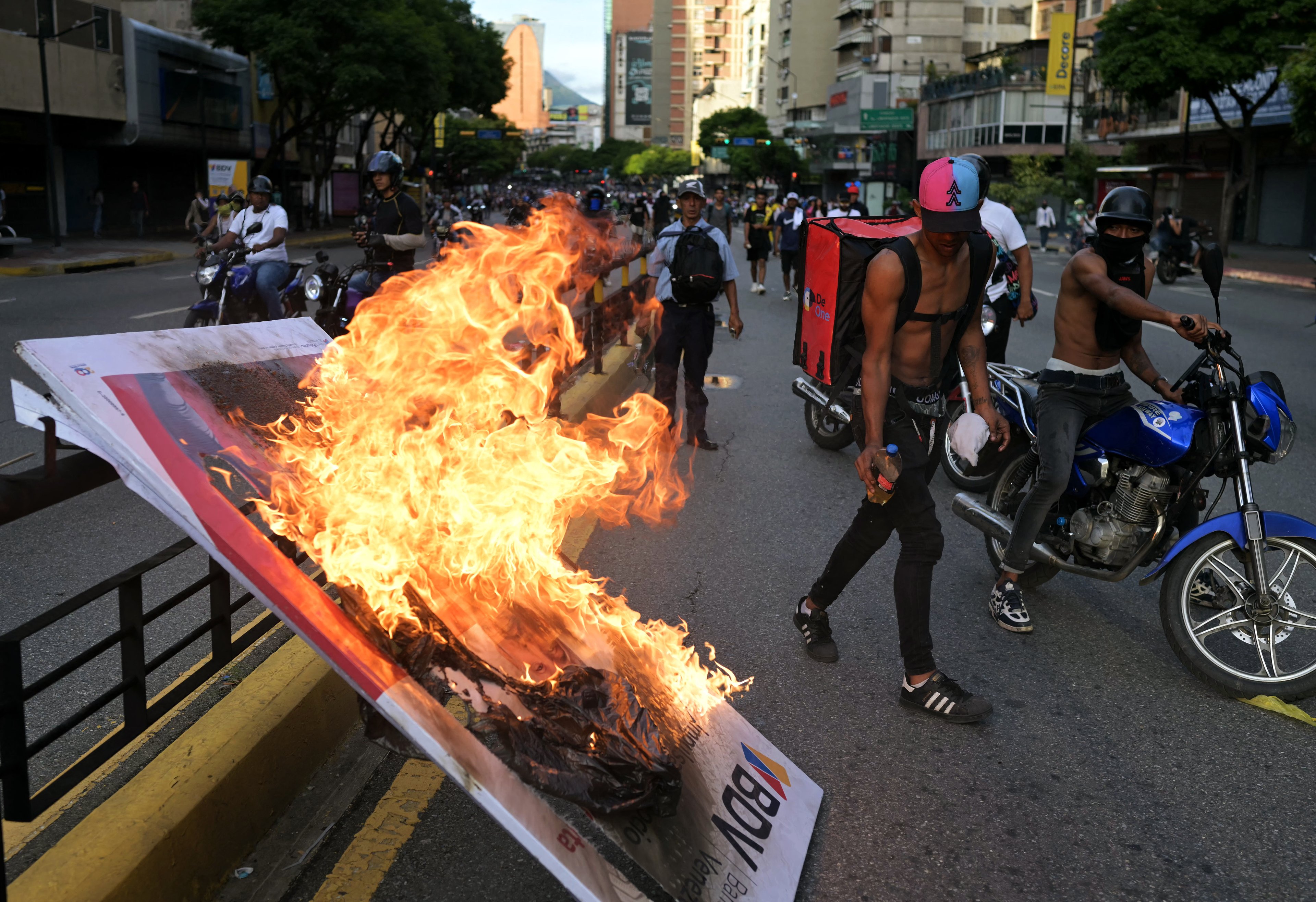 Manifestantes queimam um cartaz publicitário durante um protesto contra o governo do presidente venezuelano Nicolás Maduro em Caracas.