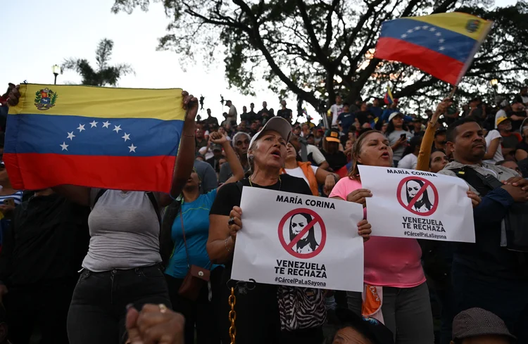 Supporters of Venezuelan President Nicolas Maduro listen to his speech while holding placards that read "Maria Corina (Machado), Venezuela rejects you" during a rally outside the Miraflores presidential palace in Caracas on July 30, 2024. Venezuela braced for new demonstrations after four people died and dozens were injured on the eve when the authorities broke up protests against President Nicolas Maduro's claim of victory in the country's hotly disputed weekend election. (Photo by Raul ARBOLEDA / AFP) (AFP)