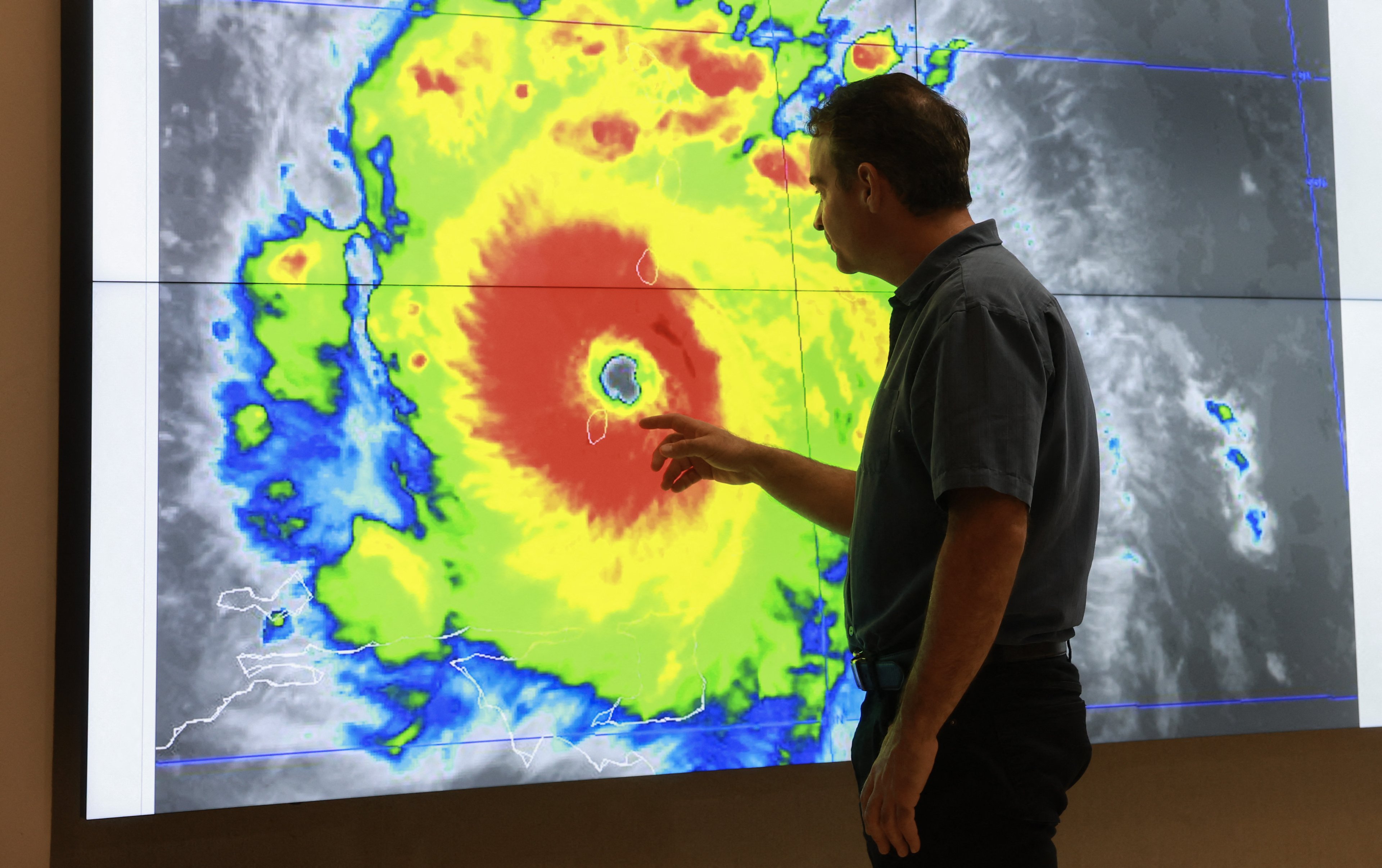 John Cangialosi, metereologista, observa dados sobre o furacão Beryl no Centro Nacional de Furacões, em Miami