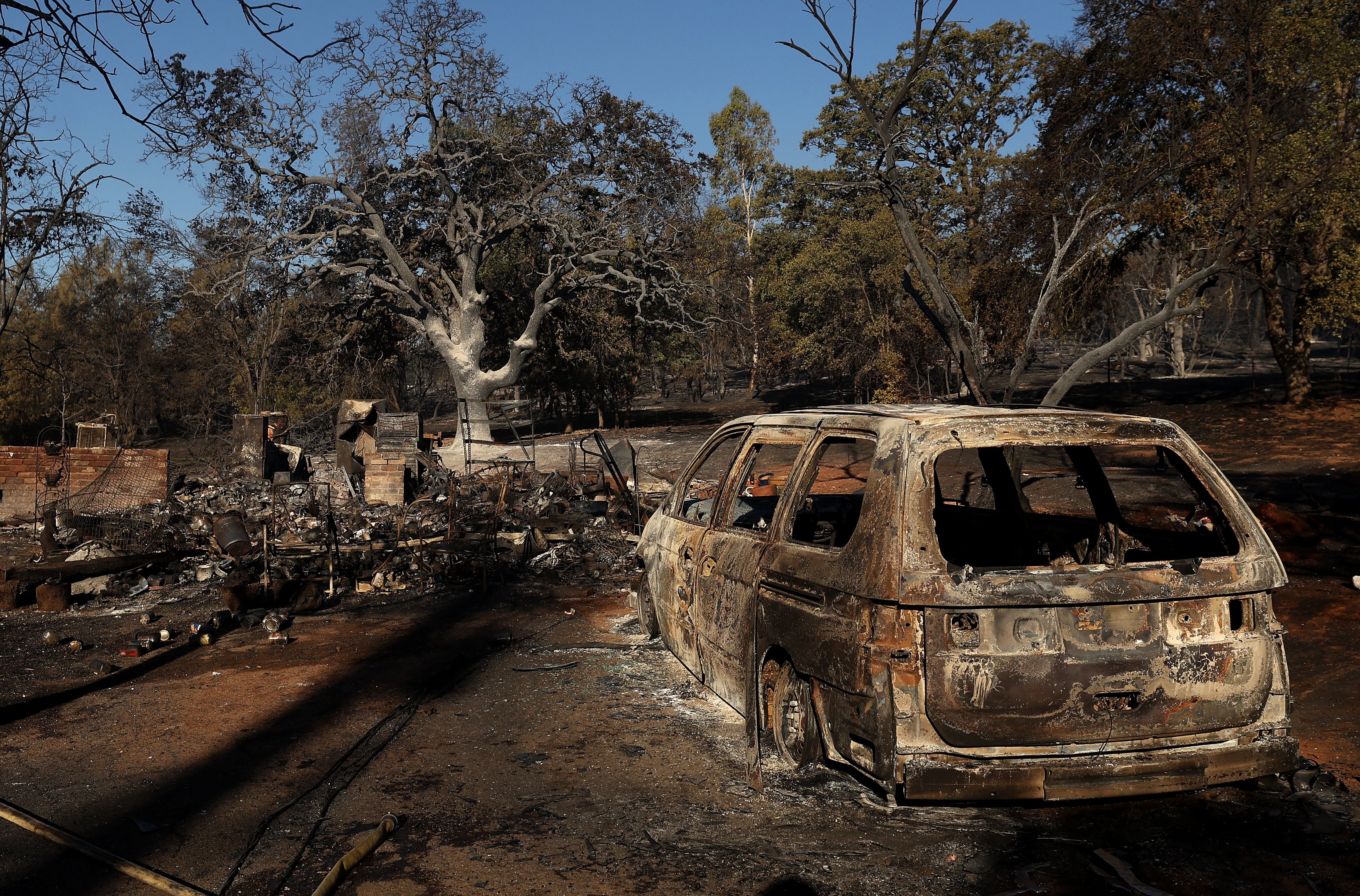 OROVILLE, CALIFORNIA - JULY 03: A burned out car sits next to a home that was destroyed by the Thompson Fire on July 03, 2024 in Oroville, California. At least 12,000 Butte County residents have been evacuated as they flee the Thompson Fire that has burned more than 3,000 acres and destroyed multiple homes since starting on Monday. The fire is zero percent contained.   Justin Sullivan/Getty Images/AFP (Photo by JUSTIN SULLIVAN / GETTY IMAGES NORTH AMERICA / Getty Images via AFP)