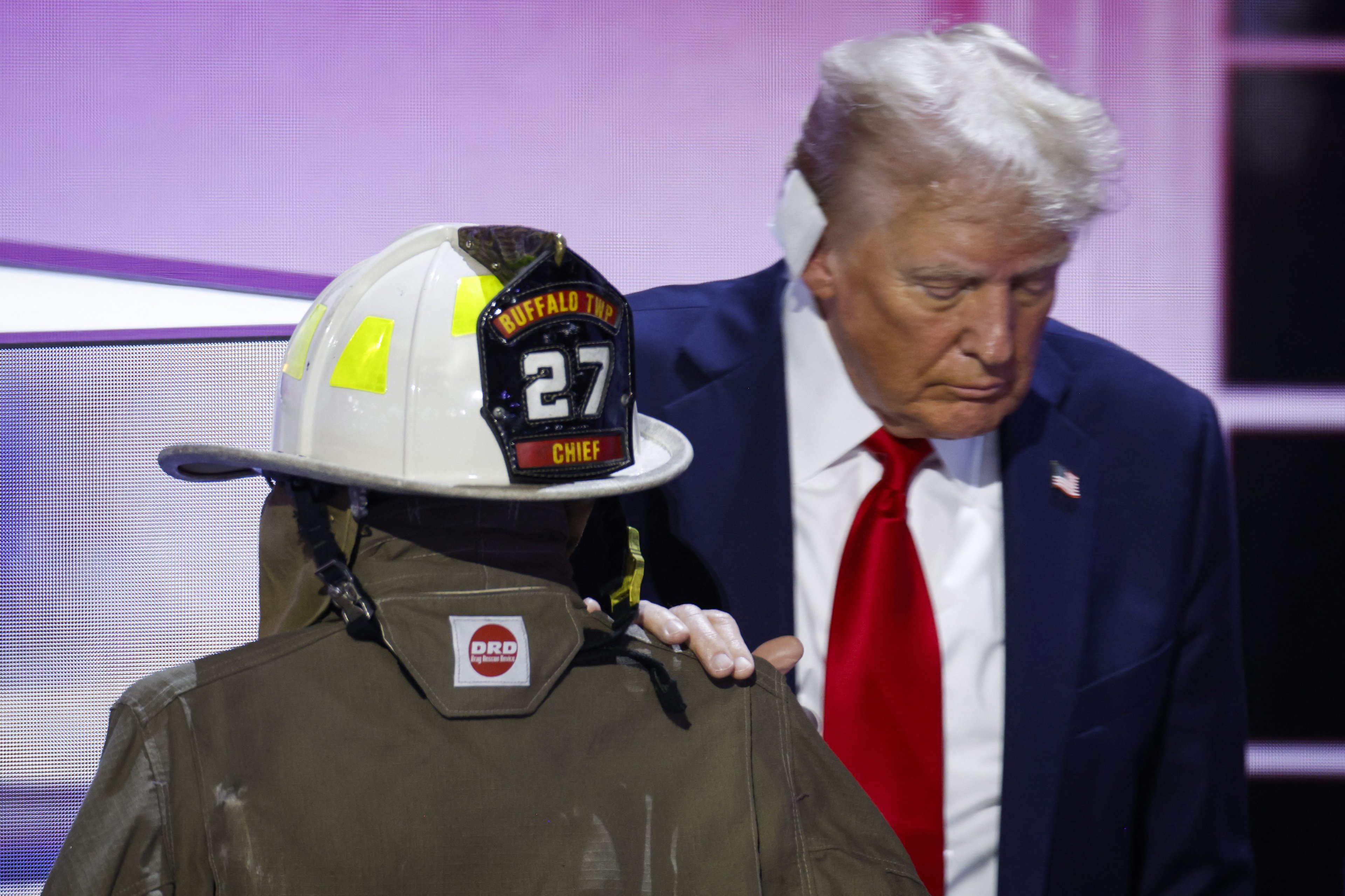 MILWAUKEE, WISCONSIN - JULY 18: Republican presidential nominee, former U.S. President Donald Trump embraces the firefighter uniform of Corey Comperatore as he speaks on stage on the fourth day of the Republican National Convention at the Fiserv Forum on July 18, 2024 in Milwaukee, Wisconsin. Delegates, politicians, and the Republican faithful are in Milwaukee for the annual convention, concluding with former President Donald Trump accepting his party's presidential nomination. The RNC takes place from July 15-18.   Chip Somodevilla/Getty Images/AFP (Photo by CHIP SOMODEVILLA / GETTY IMAGES NORTH AMERICA / Getty Images via AFP)