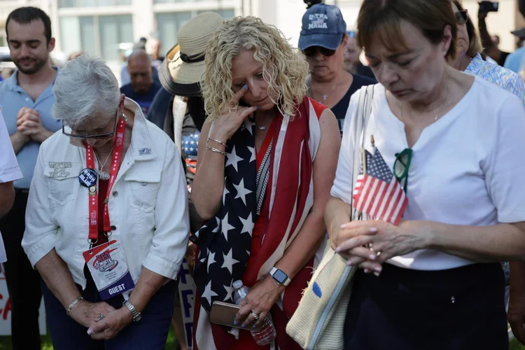 Pessoas se reúnem para orar pelo candidato republicano à presidência, o ex-presidente dos EUA Donald Trump, antes da Convenção Nacional Republicana no Zeidler Park em Milwaukee, Wisconsin, EUA, em 14 de julho de 2024.  (EFE/EFE)