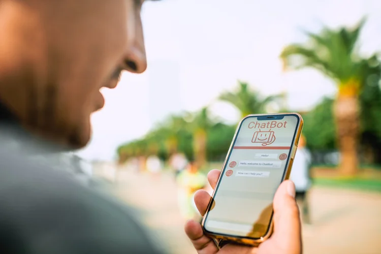 Mature man talking to a chatbot using smartphone (ArtMarie/Getty Images)