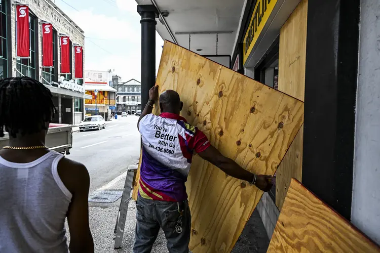 Um homem se prepara para fechar uma vitrine enquanto as pessoas se preparam para a chegada do furacão Beryl em Bridgetown, Barbados, em 30 de junho de 2024. Beryl, o primeiro furacão de 2024 (AFP/AFP)