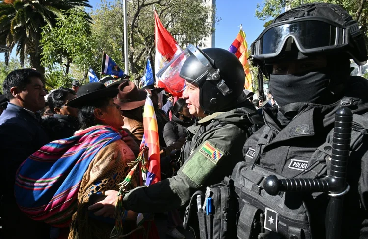 Simpatizantes do ex-presidente boliviano Evo Morales discutem com agentes antimotim na frente do Tribunal Supremo Eleitoral (TSE) durante uma reunião com partidos políticos para debater as eleições, em La Paz, em 10 de julho de 2024 (AFP)