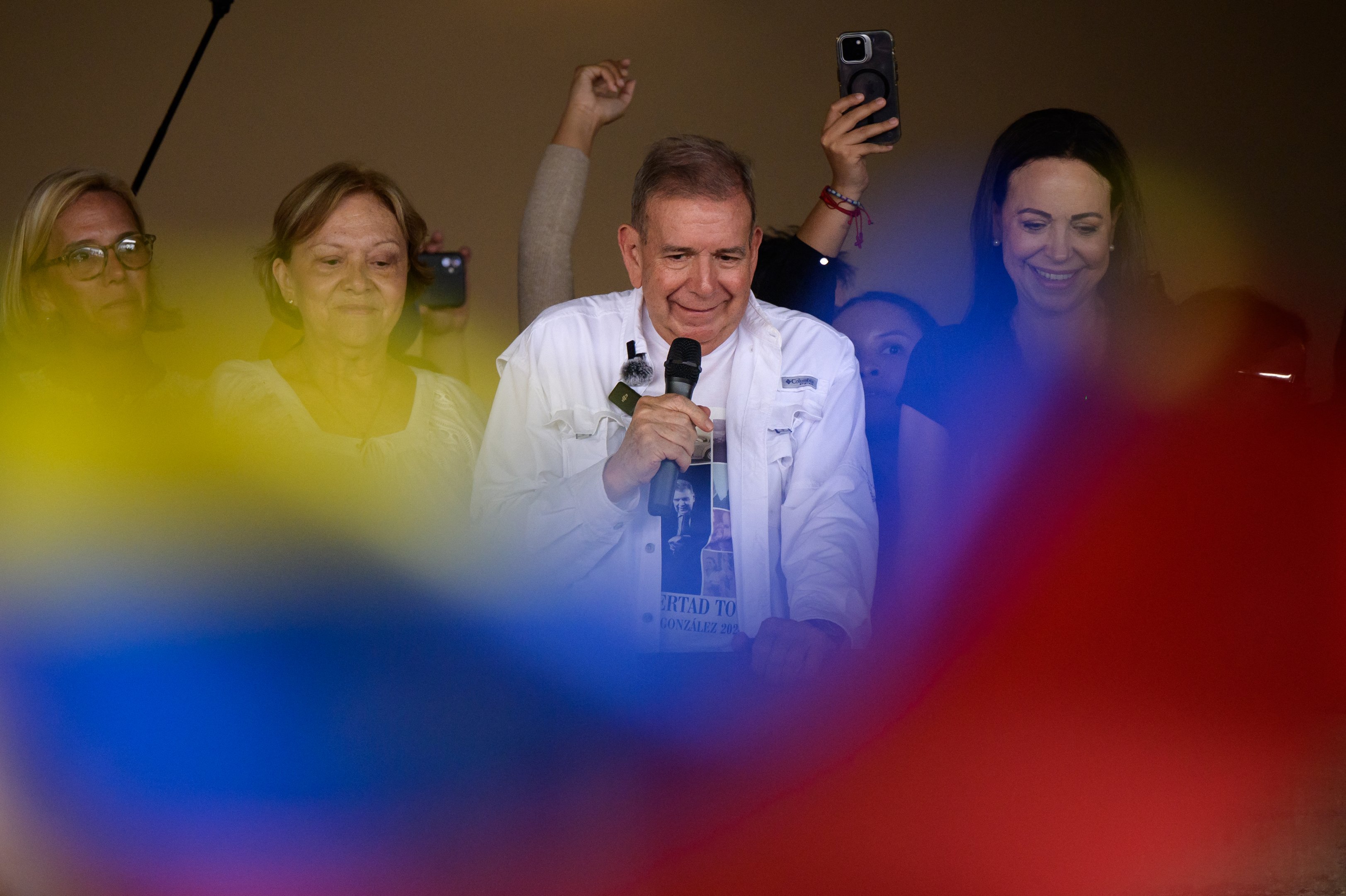 O candidato presidencial venezuelano Edmundo Gonzalez (C) fala a estudantes ao lado de sua esposa Mercedes Lopez (2ª-L) e da líder da oposição venezuelana Maria Corina Machado (R) durante um comício de campanha na Universidade Central da Venezuela em Caracas, em 14 de julho de 2024