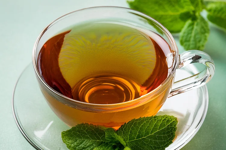 Esse chá verde com hortelã é muito usado como digestivo, perfeito após uma refeição para acalmar o estômago. A hortelã é famosa por tranquilizar a mente e aguçar os sentidos, tornando esse chá perfeito para qualquer hora do dia. Particularmente refrescante nos dias de verão. ( Imagem gerada por inteligência artificial/Adobe Firefly/Exame)