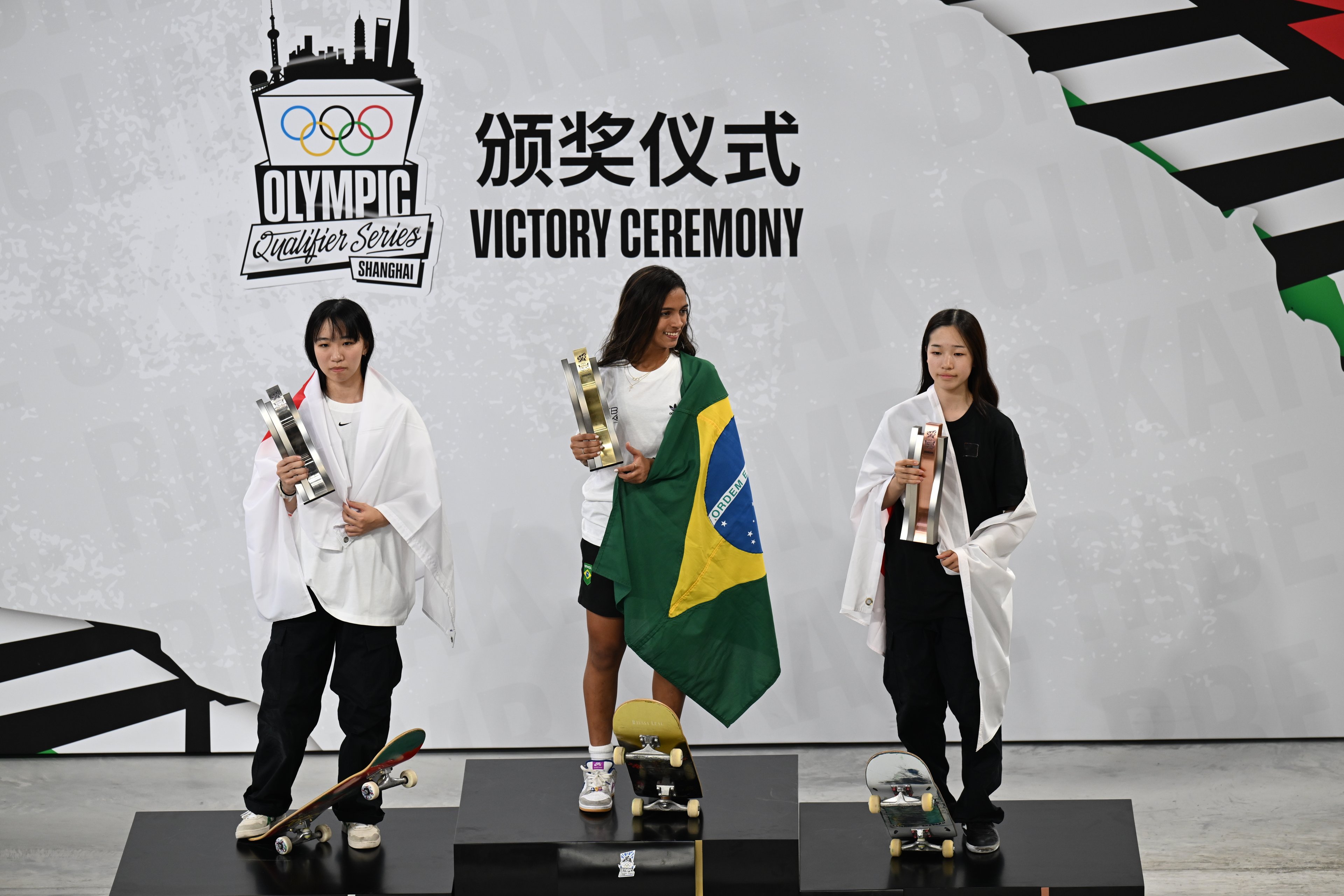 A medalhista de prata Liz Akama do Japão, a medalhista de ouro Rayssa Leal do Brasil e a medalhista de bronze Koko Yoshizawa do Japão posam para uma foto durante a cerimônia de premiação da Final Feminina de Skate Street no quarto dia do Olympic Qualifier Series Shanghai, em 19 de maio de 2024 em Xangai, China.