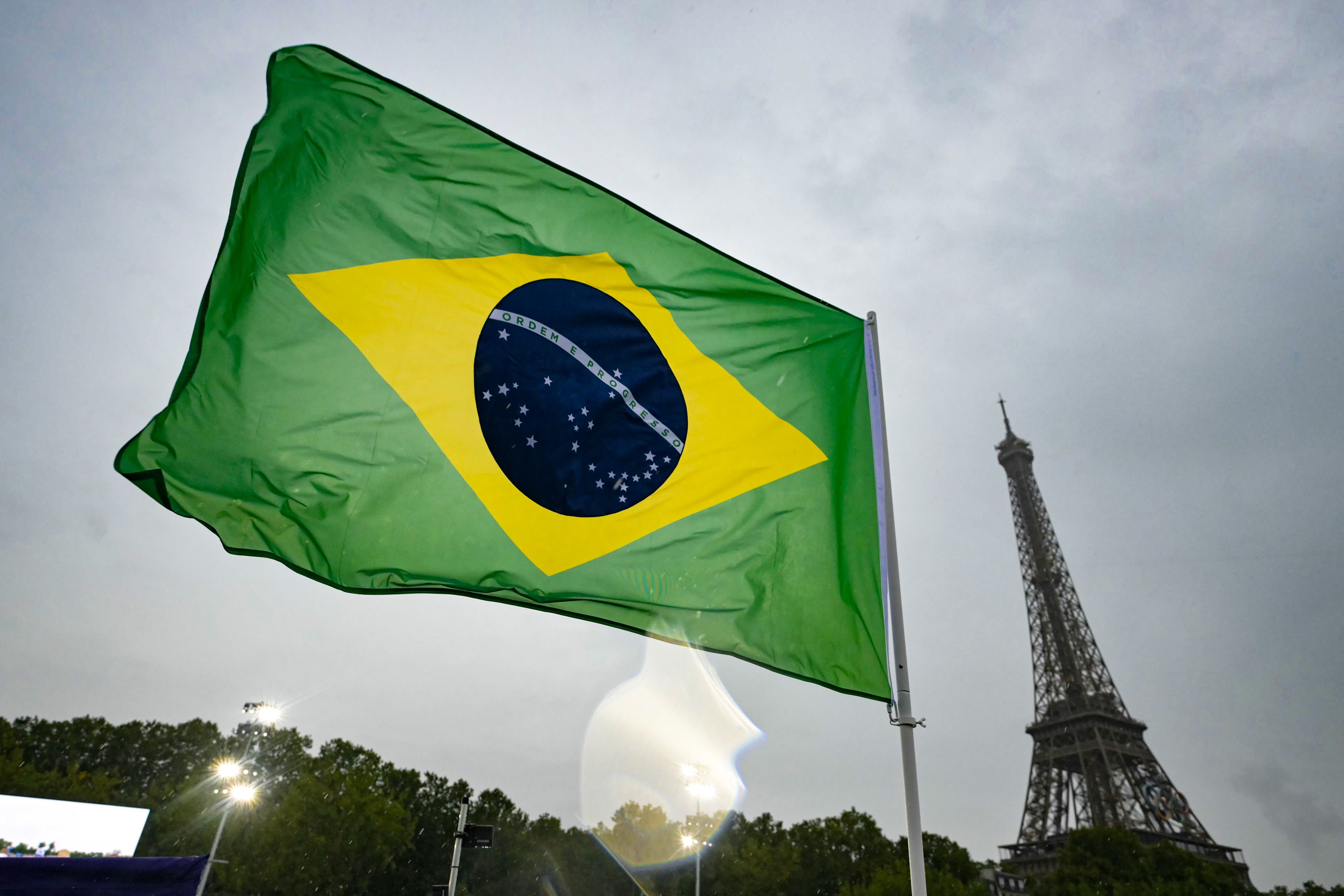 A bandeira brasileira tremula abaixo da Torre Eiffel no barco dos atletas do time Brasil ao longo do Rio Sena durante a cerimônia de abertura dos Jogos Olímpicos Paris 2024
