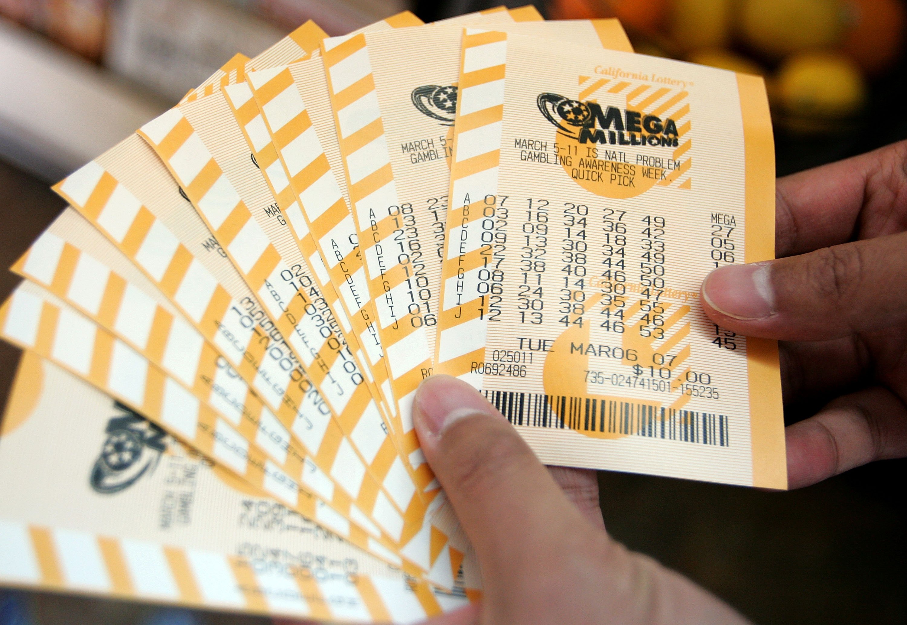 SAN FRANCISCO - MARCH 06:   A man holds a bundle of Mega Millions lottery tickets that he just purchased March 6, 2007 in San Francisco, California. The lottery jackpot was up to $370 million for tonight's drawing, which will take place in New York's Times Square instead of the usual drawing location in Atlanta.  (Photo by Justin Sullivan/Getty Images)