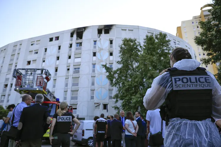 Um policial forense trabalha fora de um prédio depois que bombeiros franceses extinguiram um incêndio que eclodiu durante a noite em um prédio residencial, matando sete pessoas ( Valery HACHE /AFP)