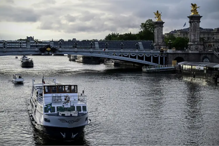 Um barco navega pelo rio Sena, perto da ponte Alexandre III, em Paris, no dia 17 de junho de 2024 (AFP)