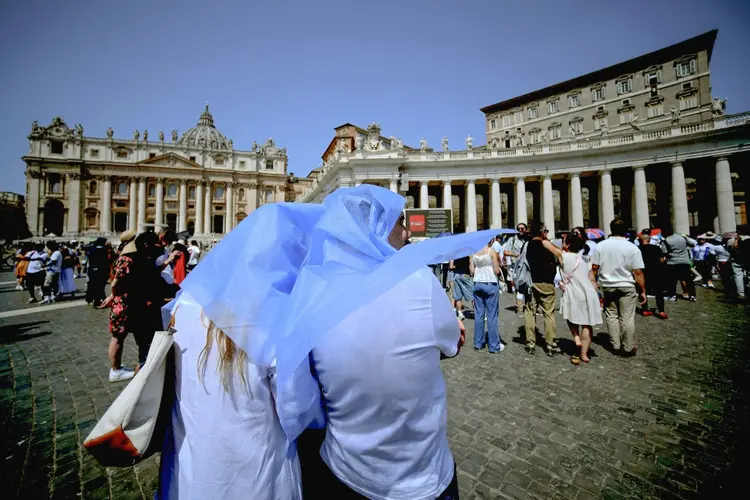 Termômetro: pessoas se protegem do sol enquanto acompanham a oração do Ângelus, conduzida pelo papa Francisco na praça de São Pedro, no Vaticano, em 21 de julho de 2024

 (AFP Photo)