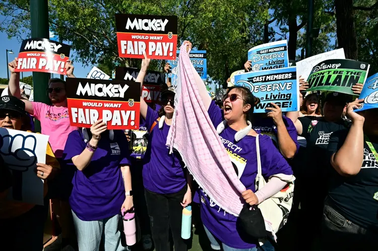 Centenas de funcionários da Disneylândia protestaram em frente aos parques temáticos da empresa em Anaheim, Califórnia (AFP)