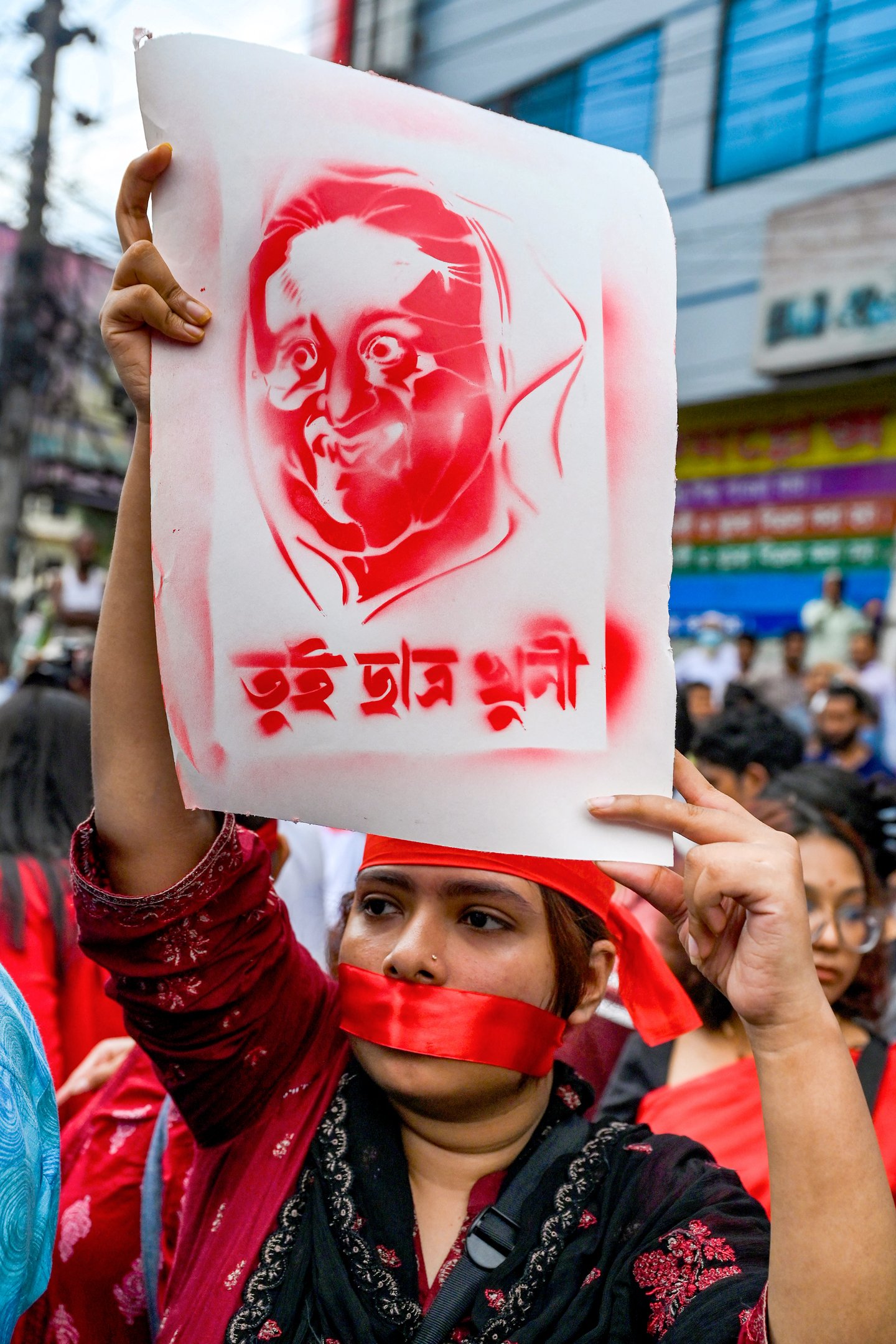 Um ativista segura um cartaz retratando a primeira-ministra de Bangladesh, Sheikh Hasina, em uma marcha musical pelas vítimas que foram mortas durante os recentes protestos estudantis nacionais sobre cotas em empregos públicos, em Dhaka, em 30 de julho de 2024. O governo de Bangladesh convocou um dia de luto em 30 de julho pelas vítimas da violência em distúrbios nacionais, mas os estudantes denunciaram o gesto como desrespeitoso aos colegas de classe mortos durante confrontos com a polícia neste mês