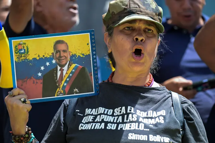 Uma apoiadora do candidato presidencial da oposição Edmundo Gonzalez Urrutia e a líder da oposição Maria Corina Machado gritam slogans durante um protesto em frente à sede das Nações Unidas em Caracas em 30 de julho de 2024 (Yuri Cortez/AFP)