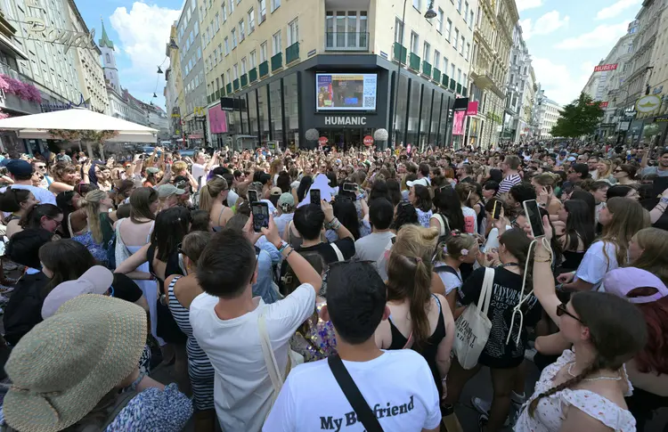 Fãs da cantora em Viena tentam se informar em telão sobre cancelamento de shows ((Photo by ROLAND SCHLAGER / APA / AFP) / Austria OUT)