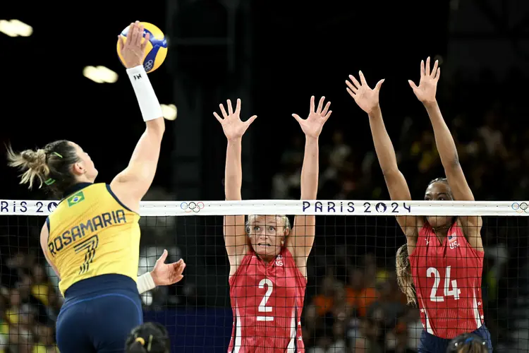 Brazil's #07 Rosamaria Montibeller spikes the ball as US' #02 Jordyn Poulter and US' #24 Chiaka Ogbogu try to block during the women's volleyball semi-final match between Brazil and USA at the South Paris Arena 1 in Paris on August 8, 2024 during the Paris 2024 Olympic Games. (Photo by Natalia KOLESNIKOVA / AFP) (Natalia KOLESNIKOVA /AFP)