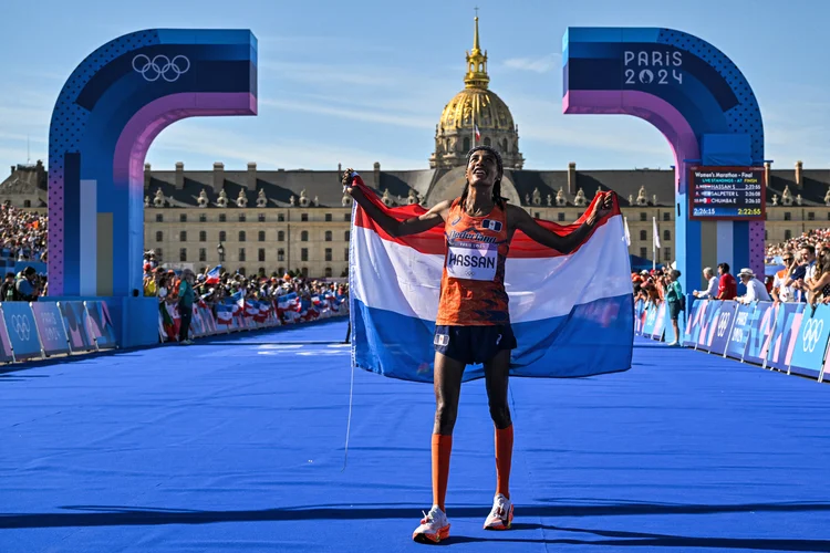 A medalhista de ouro da Holanda, Sifan Hassan, comemora após cruzar a linha de chegada em primeiro lugar na maratona feminina do evento de atletismo nos Jogos Olímpicos de Paris 2024 (Andrej ISAKOVIC/AFP)