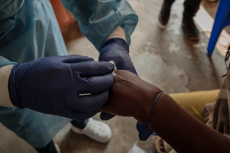 Um profissional de saúde coleta uma amostra no centro de tratamento de Mpox do hospital geral de referência de Nyiragongo, ao norte da cidade de Goma, na República Democrática do Congo, em 16 de agosto de 2024. O Ministro da Saúde Samuel-Roger Kamba disse em uma mensagem de vídeo que o país "registrou 15.664 casos potenciais e 548 mortes desde o início do ano", com todas as 26 províncias afetadas. A agência de saúde das Nações Unidas (ONU) estava preocupada com o aumento de casos e fatalidades na República Democrática do Congo e a disseminação para Burundi, Quênia, Ruanda e Uganda (GUERCHOM NDEBO/AFP)