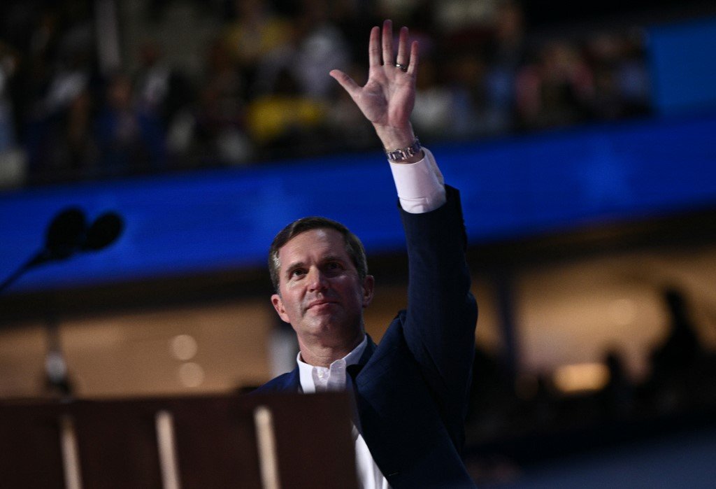 O  governador de Kentucky, Andy Beshear, acena do palco no primeiro dia da Convenção Nacional Democrata (DNC) no United Center, em Chicago, Illinois, em 19 de agosto de 2024.