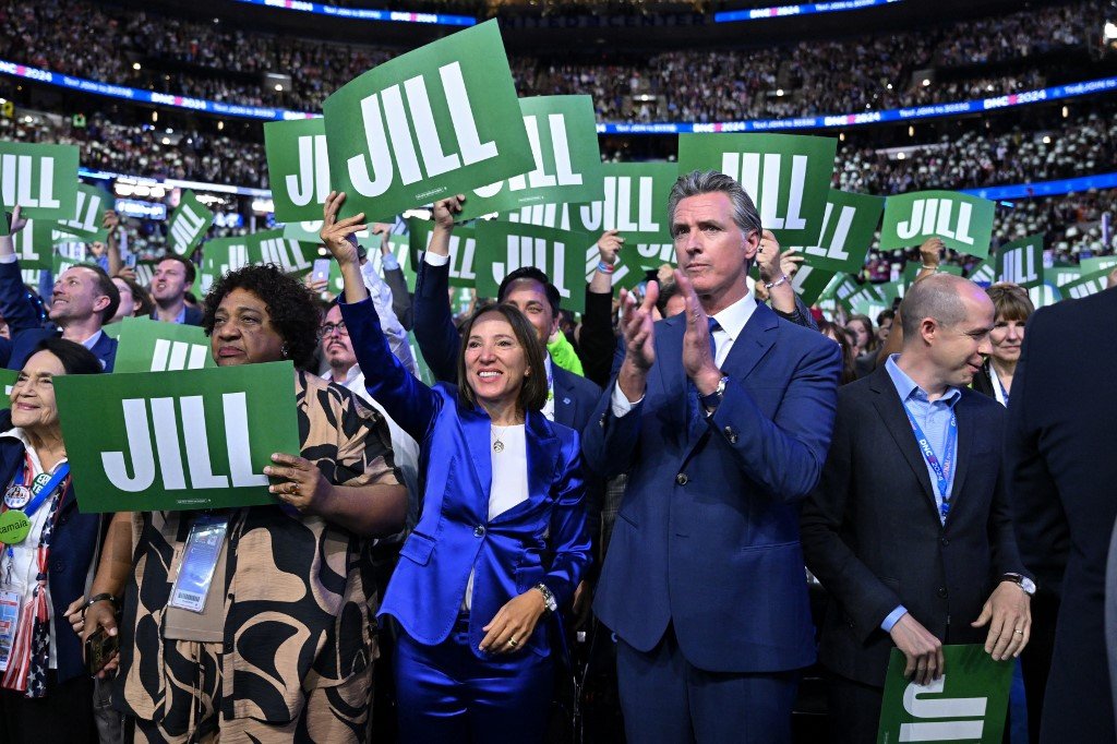 O governador da Califórnia, Gavin Newsom, aplaude enquanto a primeira-dama dos EUA, Jill Biden, discursa no primeiro dia da Convenção Nacional Democrata (DNC) no United Center, em Chicago, Illinois, em 19 de agosto de 2024.