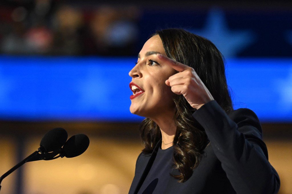 A representante dos EUA Alexandria Ocasio-Cortez (D-NY) acena enquanto sai do palco após discursar no primeiro dia da Convenção Nacional Democrata (DNC) no United Center, em Chicago, Illinois, em 19 de agosto de 2024