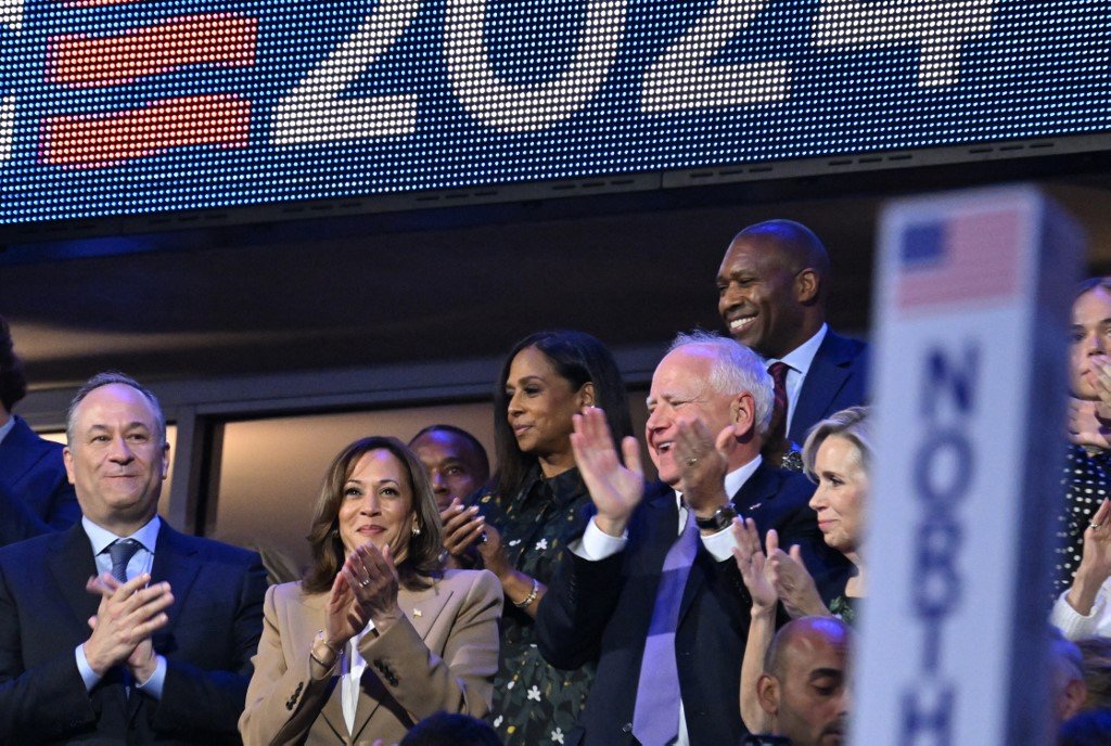 US Second Gentleman Douglas Emhoff (L), US Vice President and 2024 Democratic presidential candidate Kamala Harris, Minnesota Governor and 2024 Democratic vice presidential candidate Tim Walz and his wife Gwen Walz applaud as US Senator from Georgia Raphael Warnock speaks on the first day of the Democratic National Convention (DNC) at the United Center in Chicago, Illinois, on August 19, 2024. Vice President Kamala Harris will formally accept the partys nomination for president at the DNC which runs from August 19-22 in Chicago. (Photo by Robyn Beck / AFP)