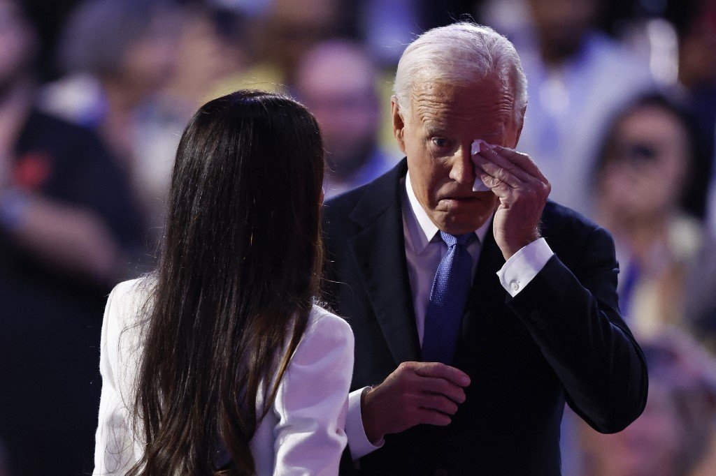 A filha do presidente dos EUA, Joe Biden, Ashley Biden, fica ao lado de seu pai, o presidente Joe Biden, enquanto ele enxuga os olhos ao chegar ao palco para discursar no primeiro dia da Convenção Nacional Democrata (DNC) no United Center, em Chicago, Illinois, em 19 de agosto de 2024. 