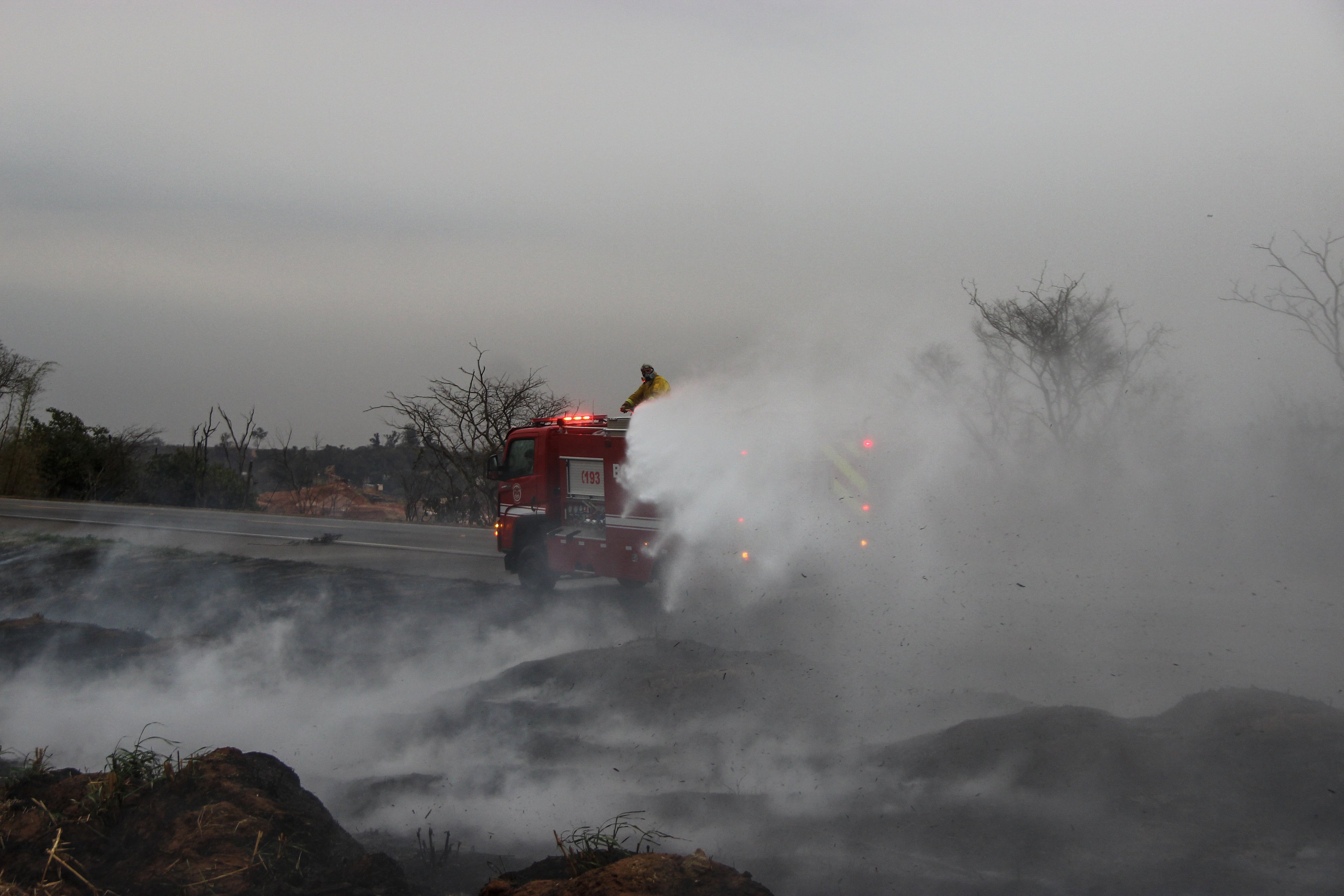 Firefighters battle a fire at the SP-215 highway in Sao Carlos, Sao Paulo state, Brazil on August 24, 2024. Forest fires in southeastern Brazil prompted a maximum alert to be declared on August 23, in around 30 cities in the state of Sao Paulo, where the fire blocked roads and smoke reached the capital Sao Paulo, according to local authorities. (Photo by Lourival Izaque / AFP)