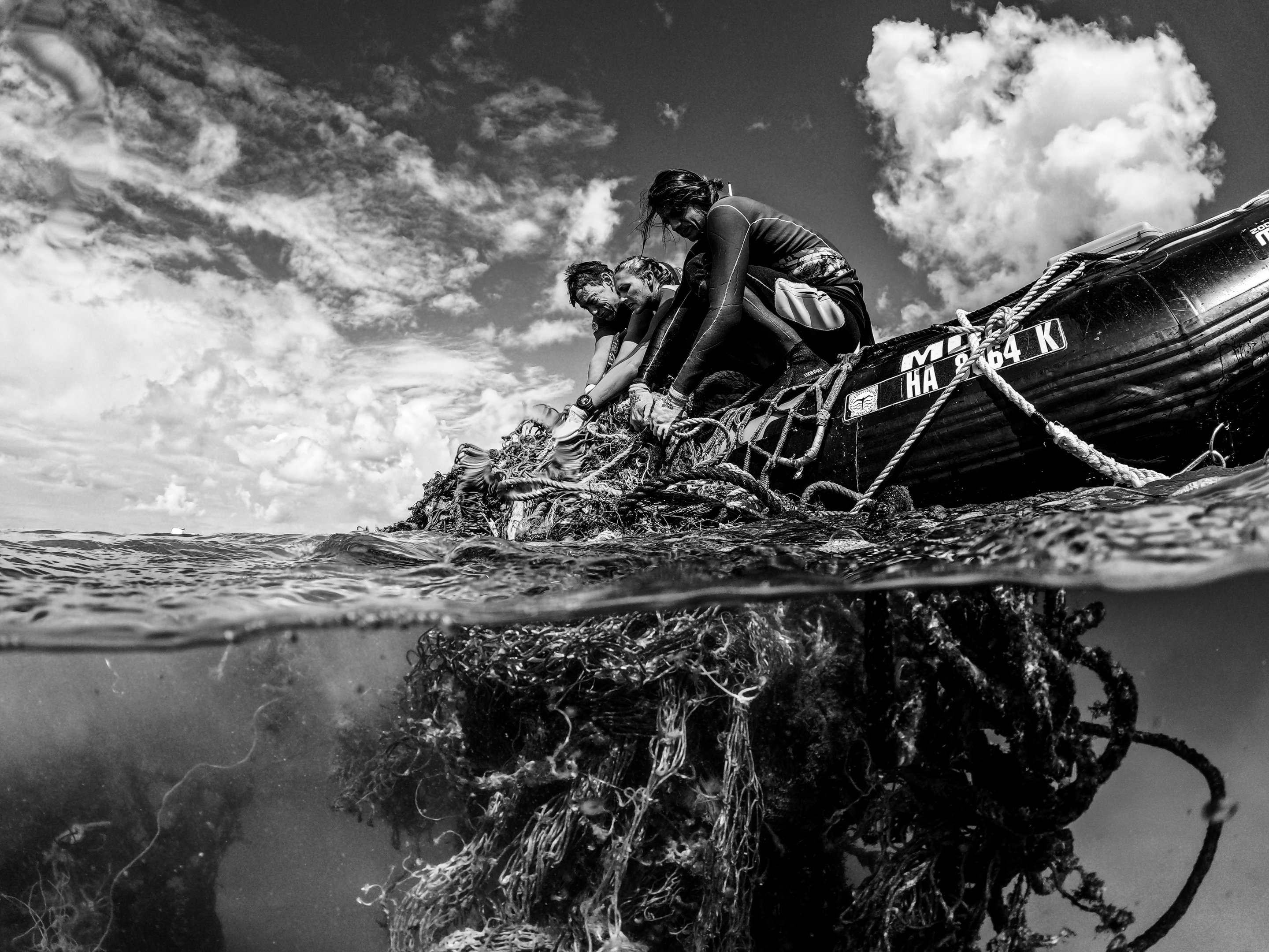 Mergulhadores do Papahānaumokuākea Marine Debris Project trabalham para remover uma grande rede fantasma das águas do desabitado Pearl and Hermes Atoll. Neste ponto, a equipe estava trabalhando por quase dois meses seguidos e removeu quase 200.000 libras de redes fantasmas desta Área Marinha Protegida. Pearl and Hermes Atoll, Havaí Imagem finalista do concurso da Oceanographic Magazine, categoria Conservation Impact, agosto 2024 plástico lixo oceano poluição natureza