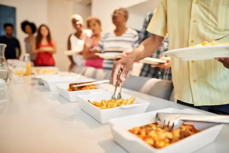 Cropped shot of family taking food from a self service buffet line on dining table at home (AJ_Watt/Getty Images)