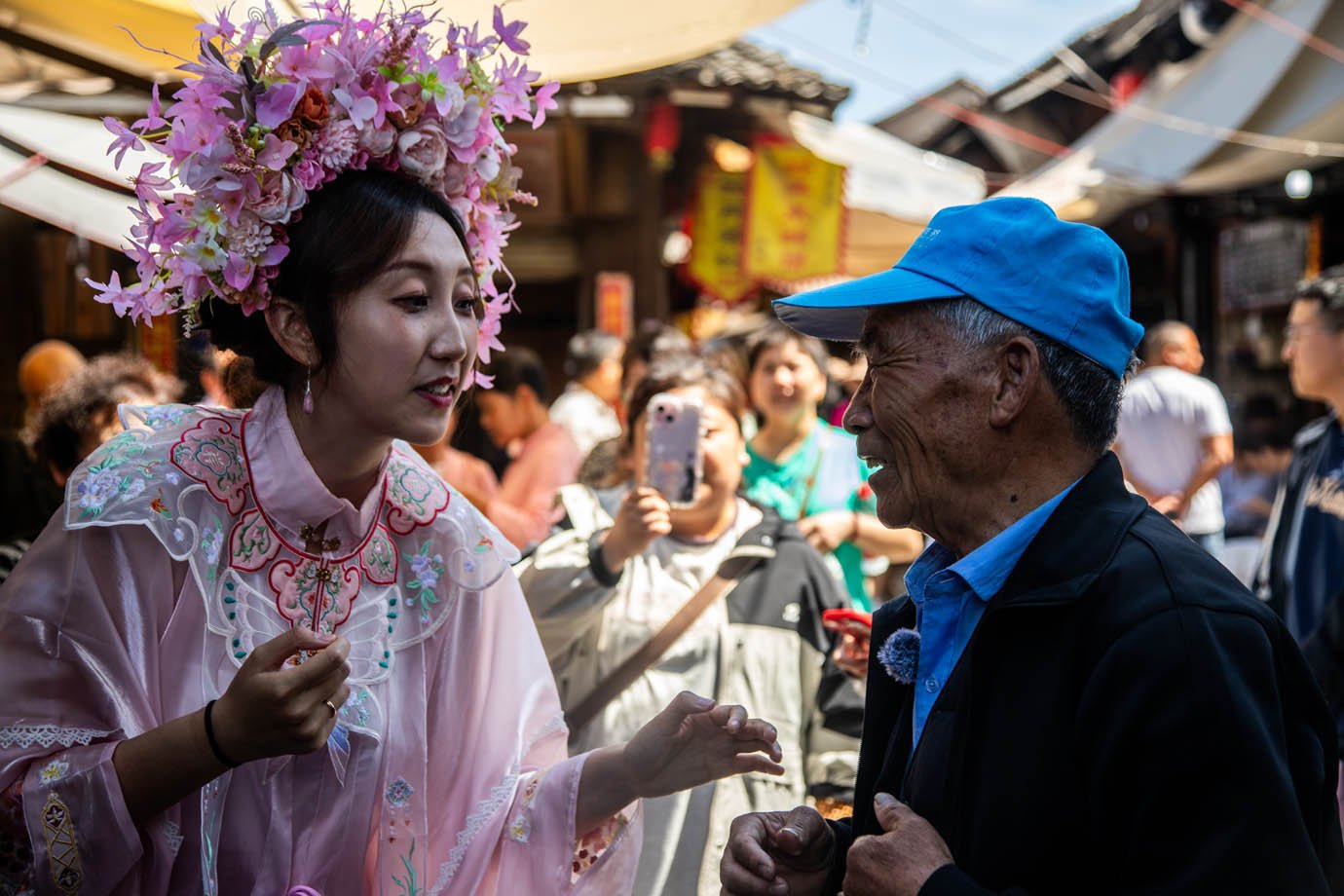 Café da manhã tradicional nas ruas da cidade milenar de Youbu, em Lanxi. Na foto, uma mulher vestida a caráter interage com os moradores locais