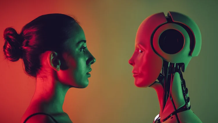 Robot and young woman face to face. (imaginima/Getty Images)