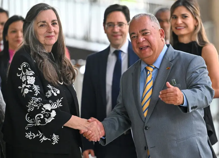 O presidente do Conselho Nacional Eleitoral (CNE) da Venezuela, Elvis Amoroso, cumprimenta a assessora do Centro Carter para América Latina e Caribe, Jennie Lincoln, em Caracas, em 16 de abril de 2024 (AFP)