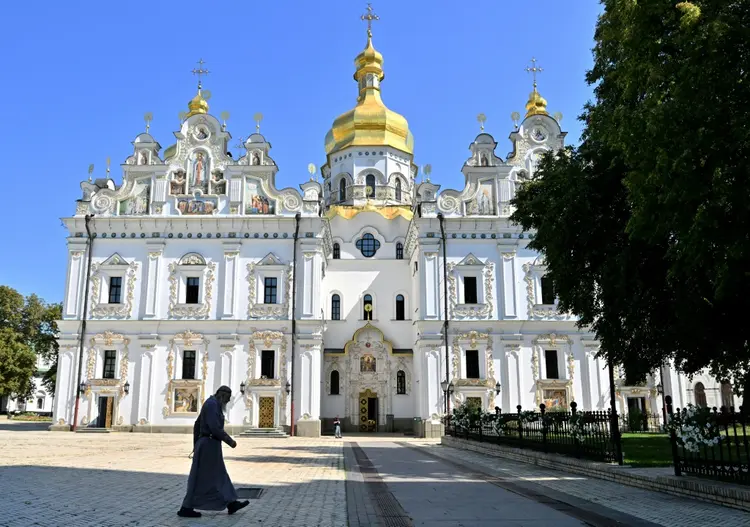 Homem passa em frente ao Mosteiro das Cavernas, em Kiev, Ucrânia, em 20 de agosto de 2024 (AFP)