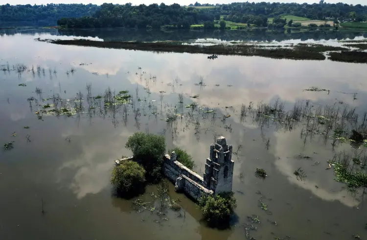 Ameaça: vista das ruínas da igreja de San Francisco, o vilarejo submerso pela represa de Endhó e sua água turva,  (afp/AFP Photo)