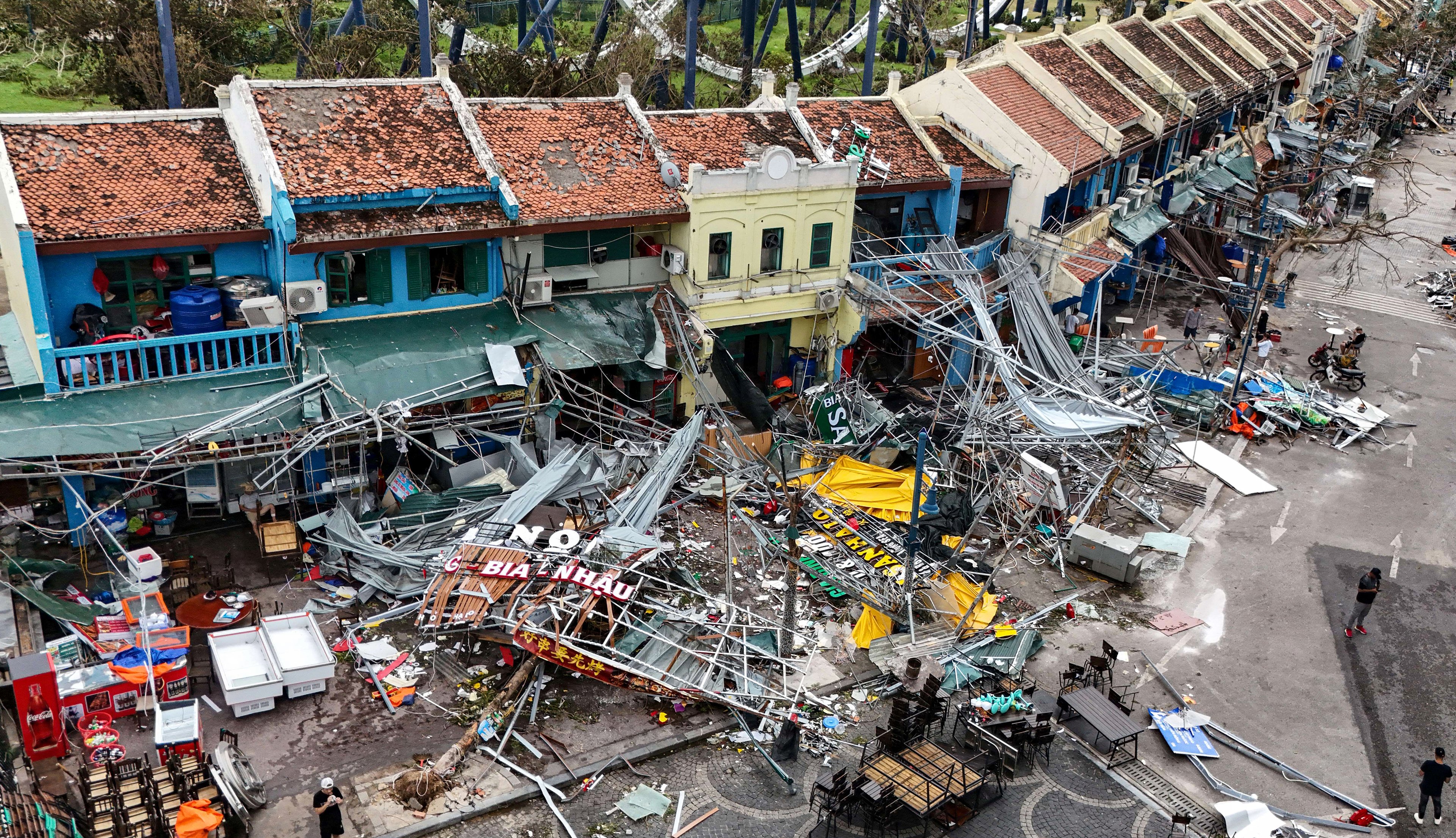 Esta imagem aérea mostra prédios danificados e destroços em uma rua após o Super Tufão Yagi atingir Ha Long, na província de Quang Ninh, em 8 de setembro de 2024. O Super Tufão Yagi arranca milhares de árvores, varre navios e barcos para o mar e arranca telhados de casas no norte do Vietnã, após deixar um rastro de destruição no sul da China e nas Filipinas