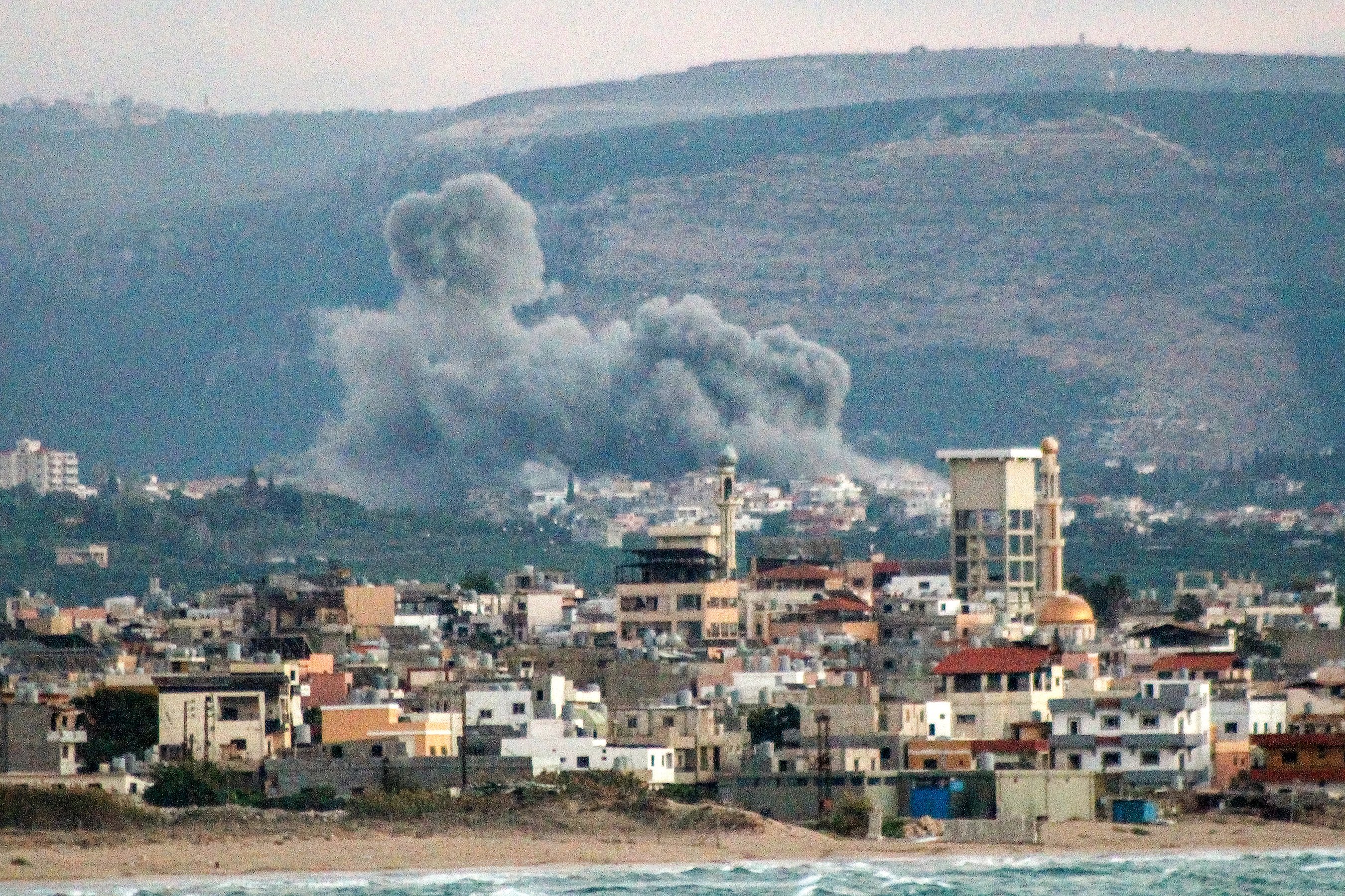 This overview from Lebanon's southern city of Tyre shows a cloud of smoke erupting after an Israeli air strike on the village of Qlayleh on September 30, 2024. (Photo by Kawnat HAJU / AFP)