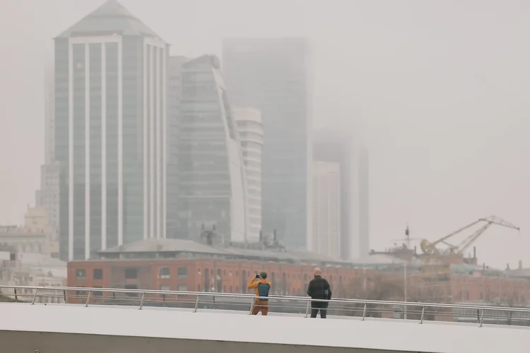 Pessoas observam uma camada de fumaça nesta terça-feira, na cidade de Buenos Aires (Argentina). O céu da Argentina, como o de outros países da região, está coberto de fumaça devido aos incêndios florestais que afetam principalmente a Amazônia oriental e norte da Bolívia (Juan Ignacio Roncoroni/EFE)