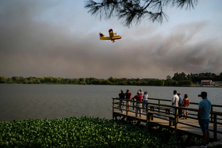 Pessoas observam os combates ao incêndio em Aveiro, Portugal, em 17 de setembro de 2024 (Levi Fernandes/AFP)