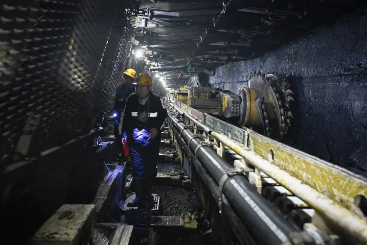 Dois mineiros no subsolo da mina de carvão Hongliulin durante uma turnê de mídia organizada pela gigante chinesa de telecomunicações Huawei, perto de Shenmu, no norte da China (Wang Zhao/AFP)