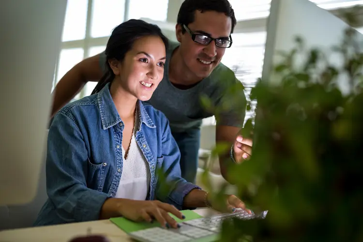 Male and female graphic designers working on computer in office