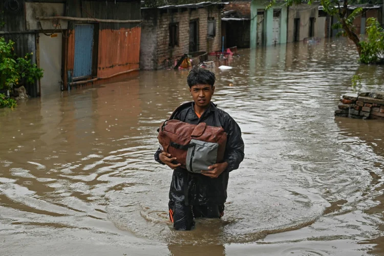 Morador caminha por ruas inundadas de Katmandu, em 28 de setembro de 2024. (AFP/AFP)